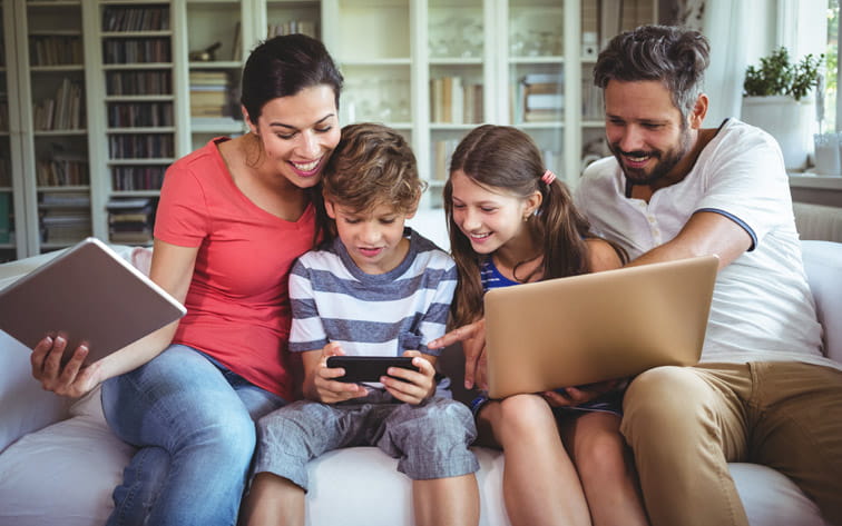 Familia con diferentes dispositivos viendo HBO Max